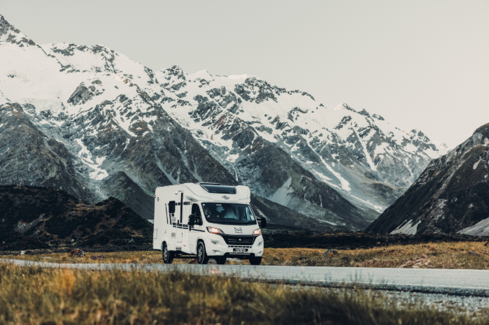 Carado Wohnmobil auf einer Straße vor schneebedeckter Berglandschaft