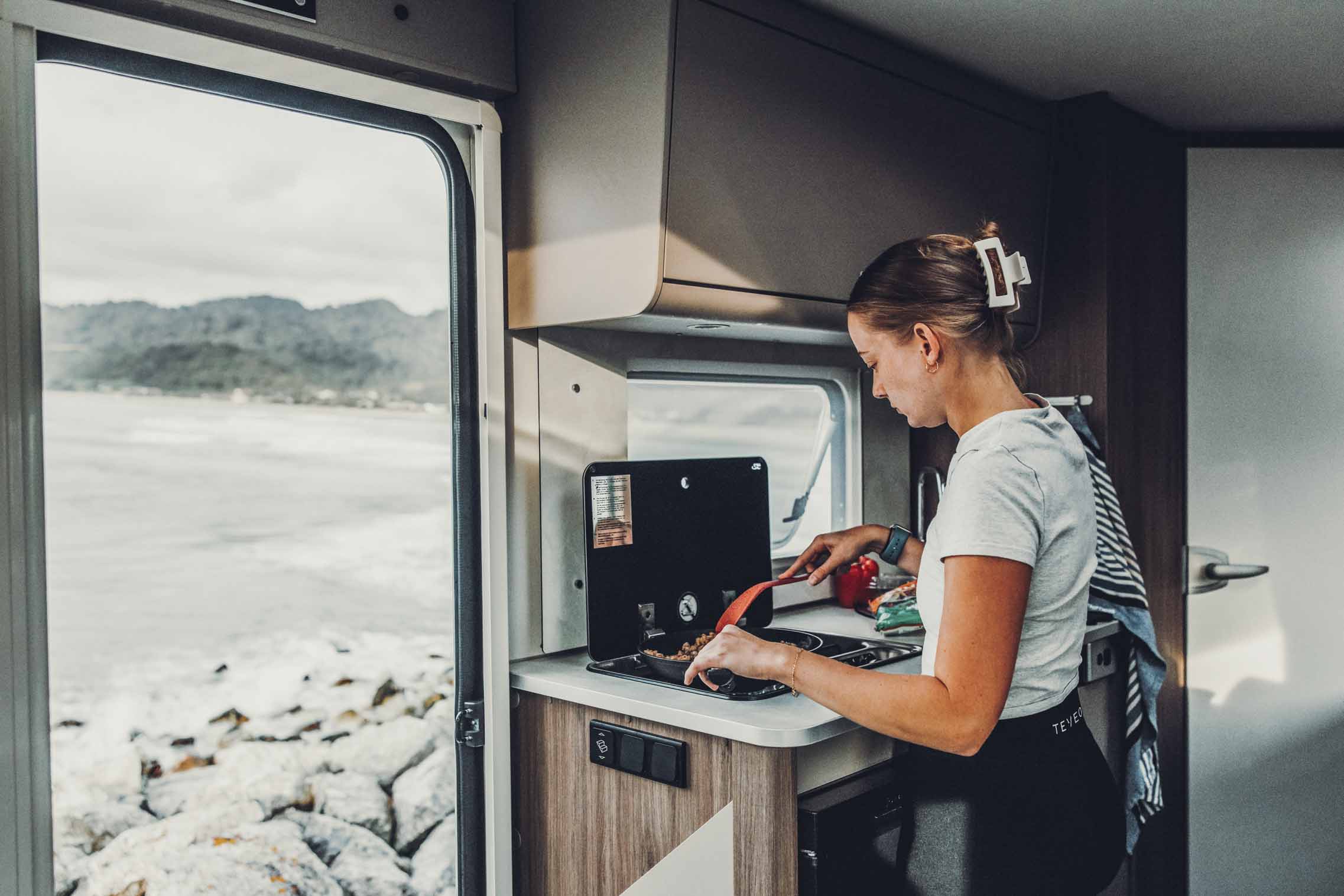 Cucina del motorcaravan con frigorifero in uso - fornello in campeggio